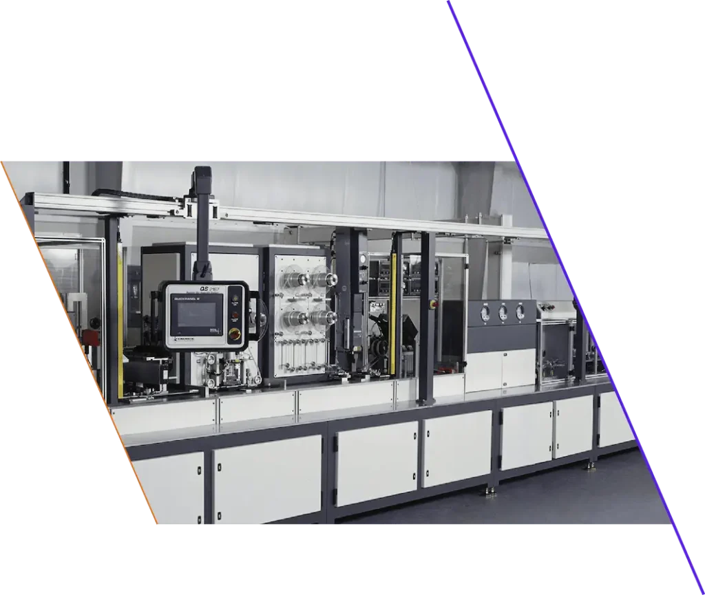 A modern automated industrial machine with control panels, display screen, and metal framework inside a clean, well-lit facility.